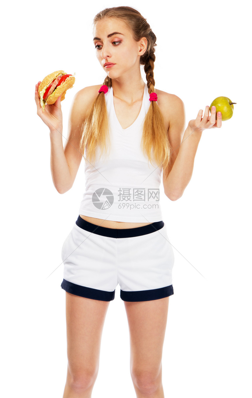 拿着汉堡包和苹果的年轻女人食物水果运动诱惑金发死亡女士白色辫子饮食图片