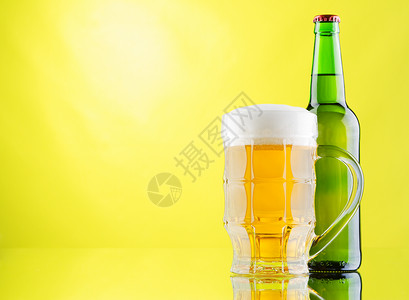 绿色啤酒黄色背景的啤酒杯和酒瓶啤酒绿色白色金子瓶子反射气泡玻璃草稿泡沫背景