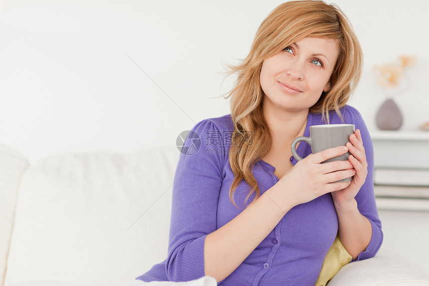漂亮的红头发女人 坐着时拿着咖啡喝着一杯咖啡图片