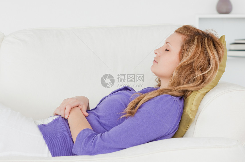 在沙发上躺着休息的迷人女人房间紫色长椅快乐女性女士身体睡眠父母眼睛图片