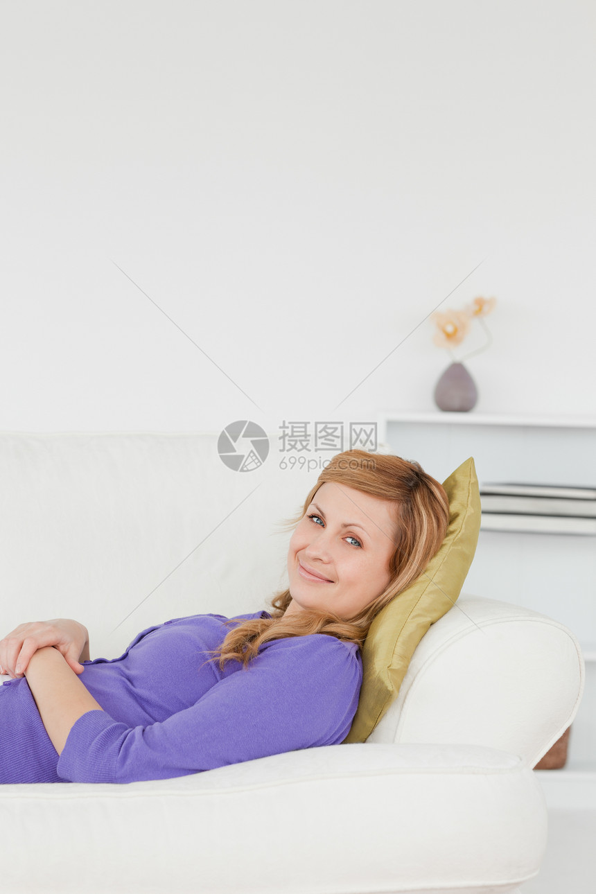 美丽的女人在沙发上躺着时休息和摆姿势父母妈妈紫色睡眠女性微笑身体眼睛快乐房间图片