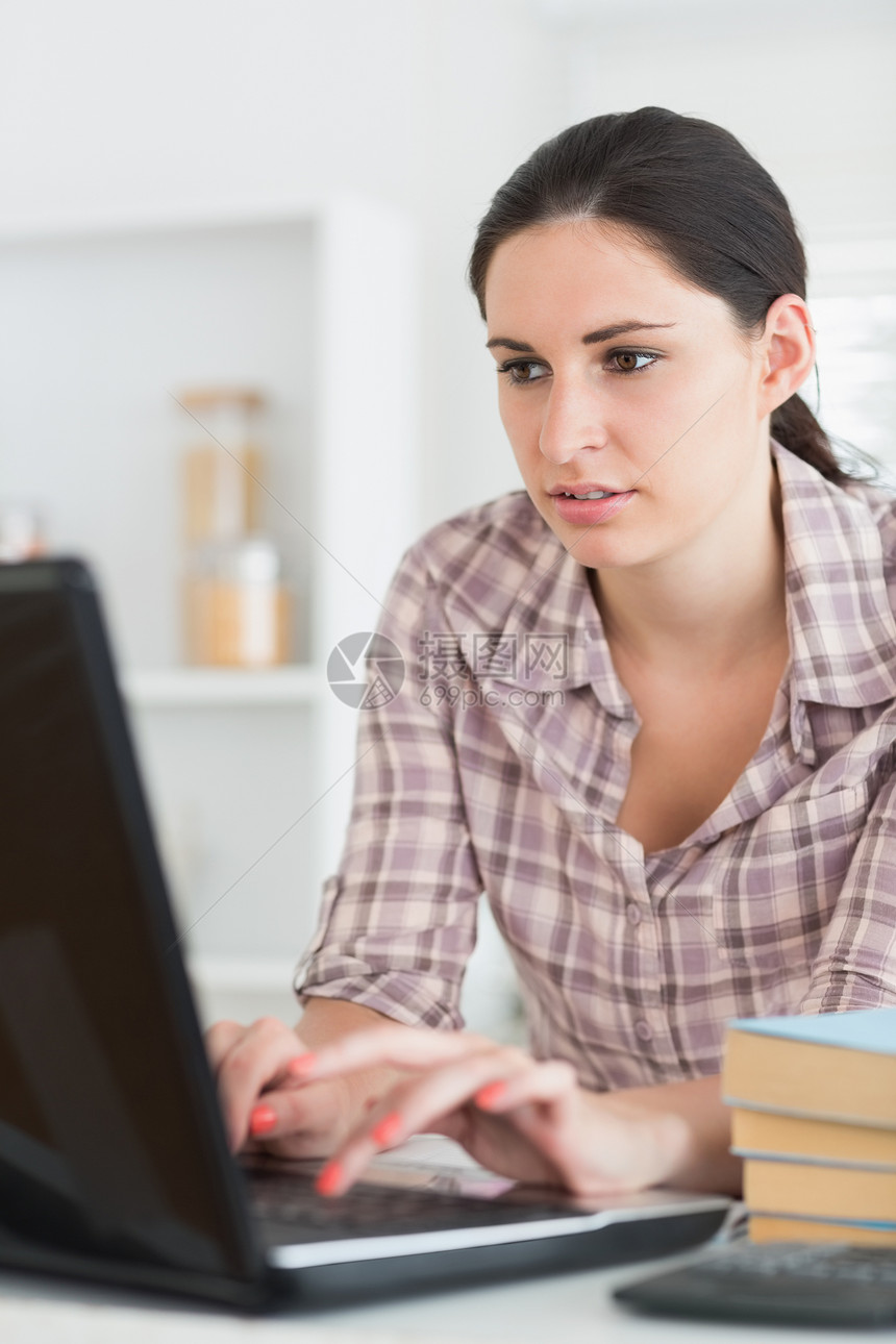 女性在计算机上打字棕色笔记本深色技术长发键盘生意人头发专注写作图片