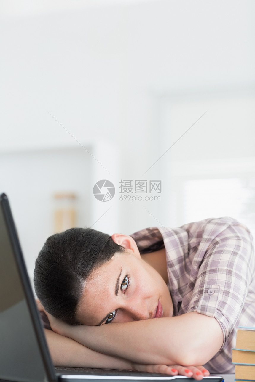 妇女用笔记本电脑靠在桌上图片