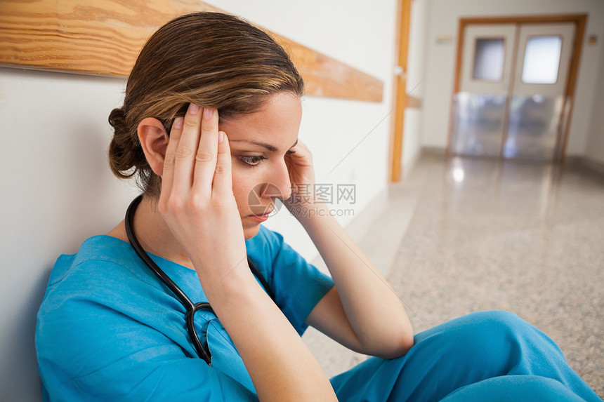 护士坐在地板上 手放在头上图片