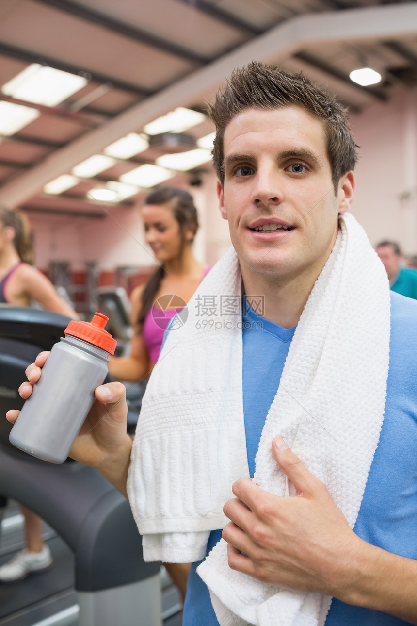 运动后休息的男子男性微笑训练肩膀机器毛巾运动服女性跑步机出汗图片