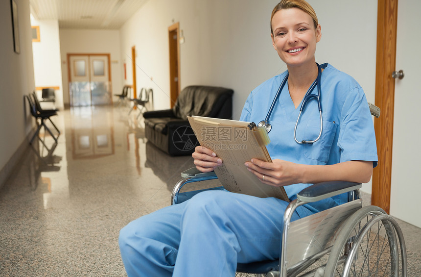护士在轮椅上微笑 拿着一个文件夹图片