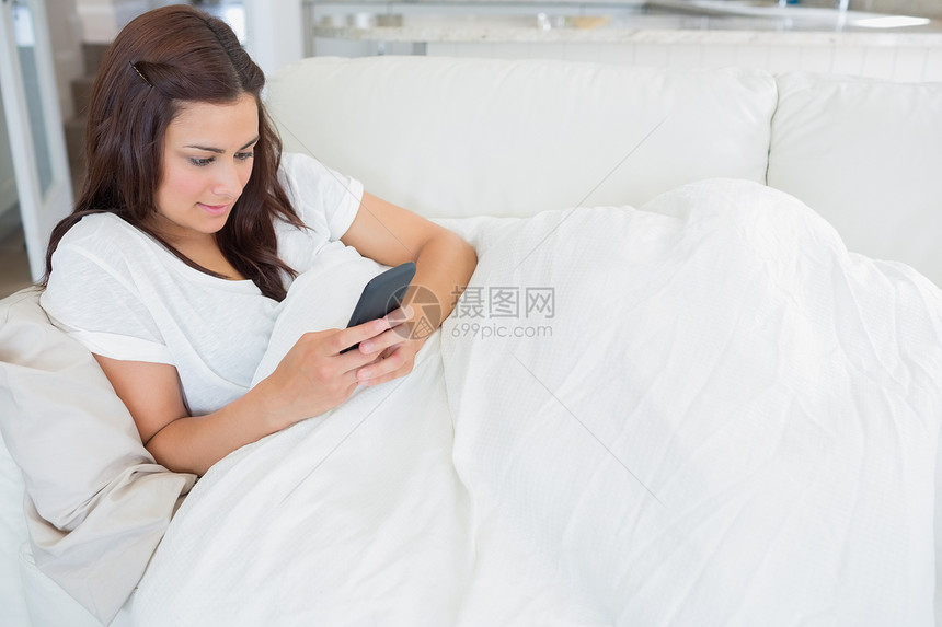 女人在发短信时躺在沙发上图片