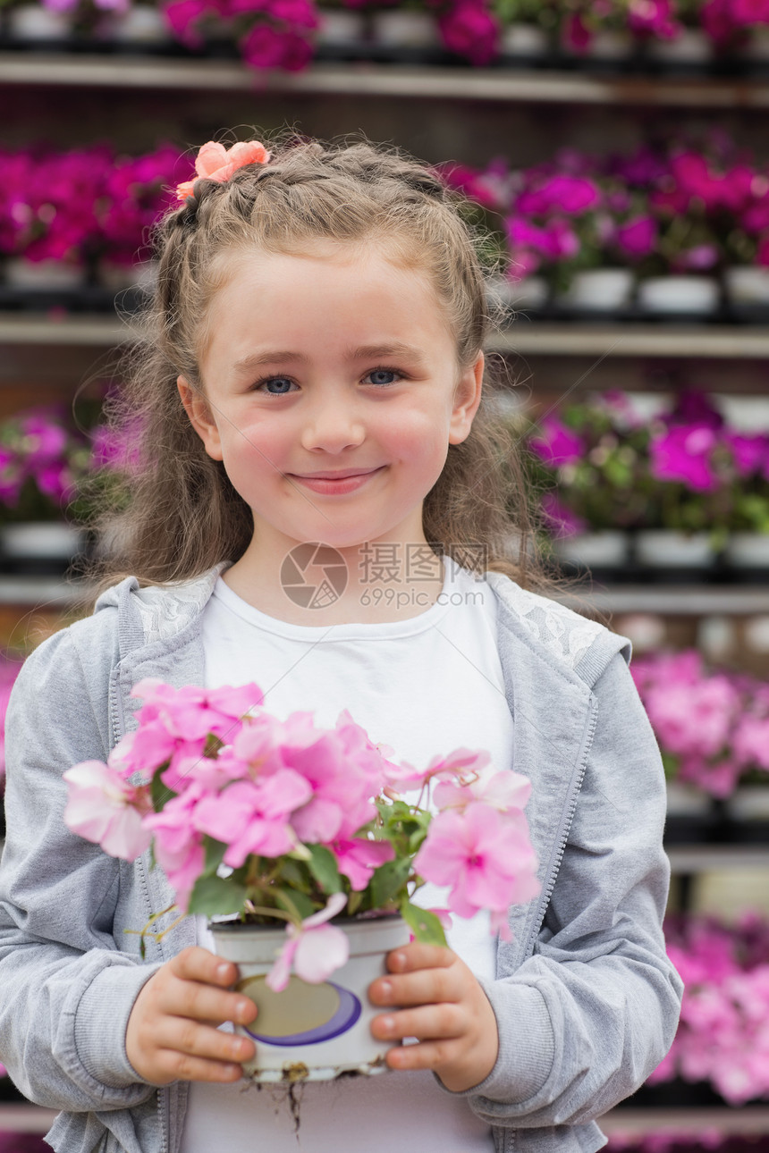 拿着植物的小女孩浅色幸福货架紫色快乐头发享受盆栽店铺女性图片