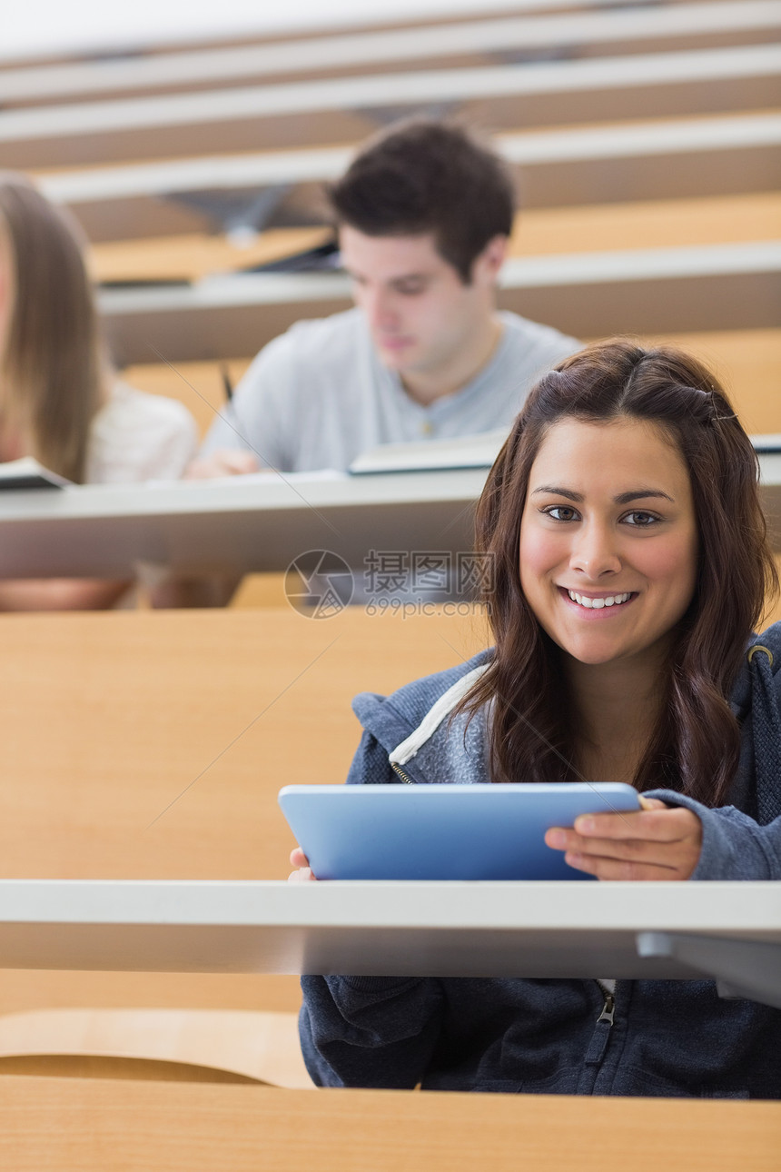 女人拿着平板电脑 在教室里微笑图片