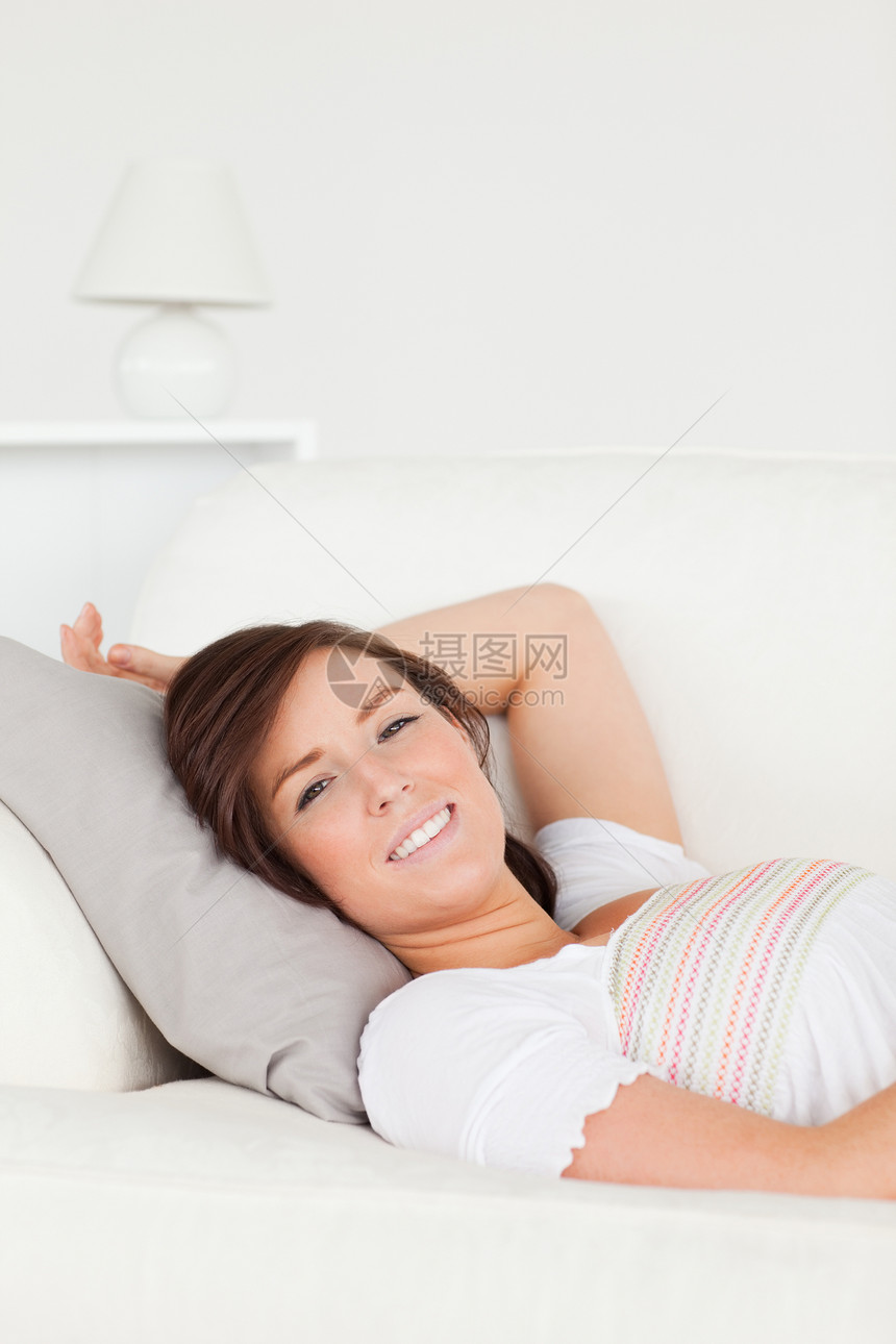 美丽的褐色女人躺在沙发上时装扮图片
