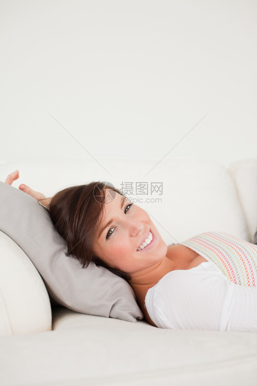 睡在沙发上时装着可爱的黑褐色女人图片