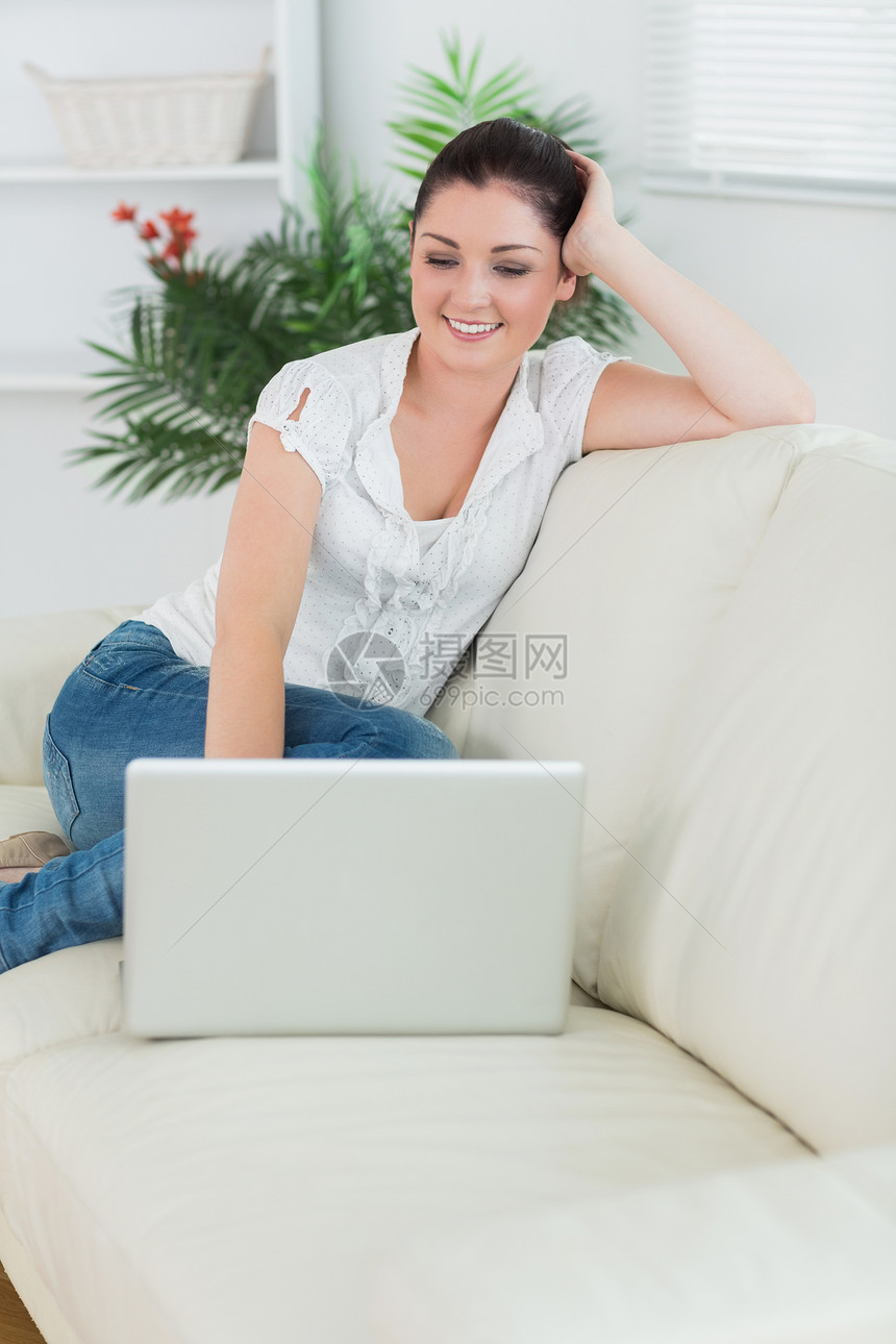 女人坐在沙发上笑着笑着使用笔记本电脑图片