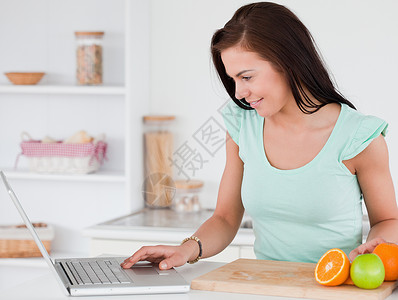 美丽苹果拥有笔记本电脑和水果的年轻妇女背景