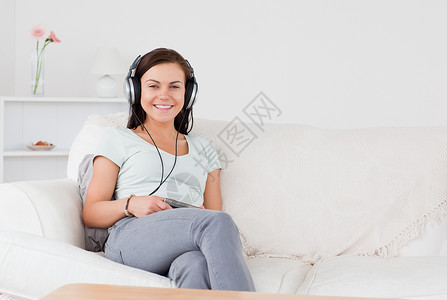 听音乐的迷人女人沙发黑发音乐播放器享受女士女孩快乐微笑音乐青年背景图片
