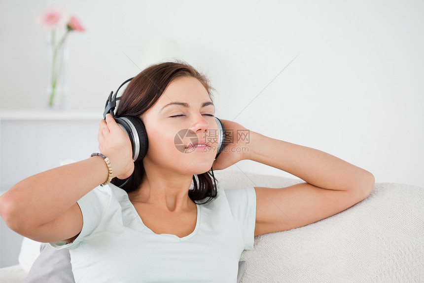 深色头发迷人的听音乐的女人图片