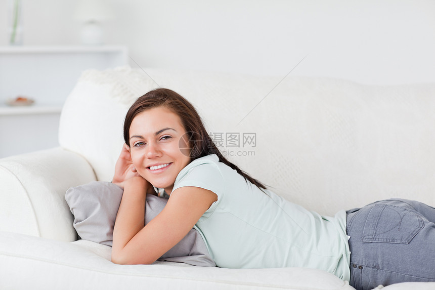 美丽的女人躺在沙发上头发快乐房子黑发幸福成人闲暇牛仔裤照片女士图片