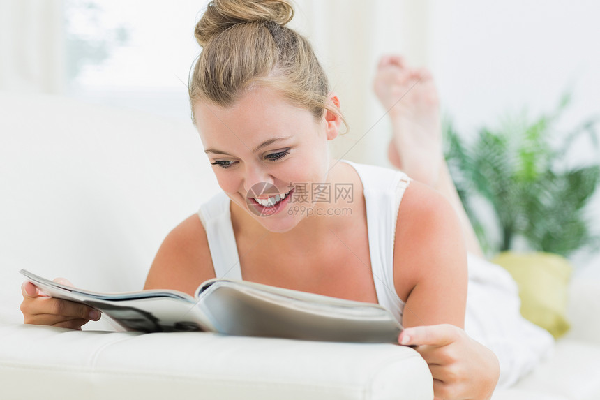 妇女微笑和阅读杂志;图片