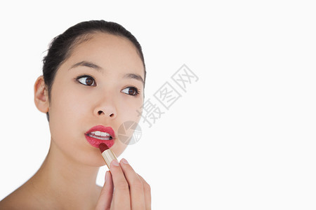 涂口红的妇女化妆品棕色黑发头发专注混血唇线女性嘴唇眼线笔背景图片