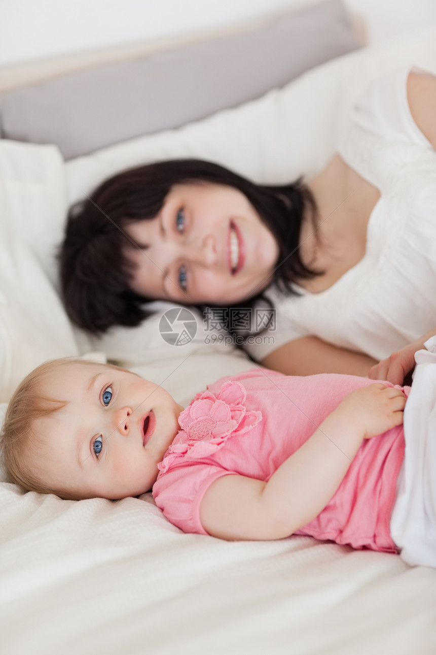 迷人的棕色黑发女性 在躺着时装着她的婴儿图片