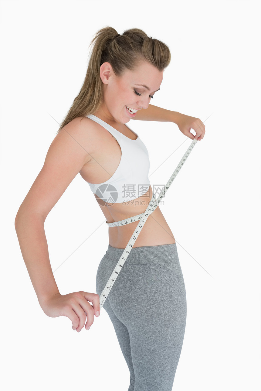 测量腰部的妇女微笑腹部头发女士重量腰带眼睛身体快乐卷尺图片
