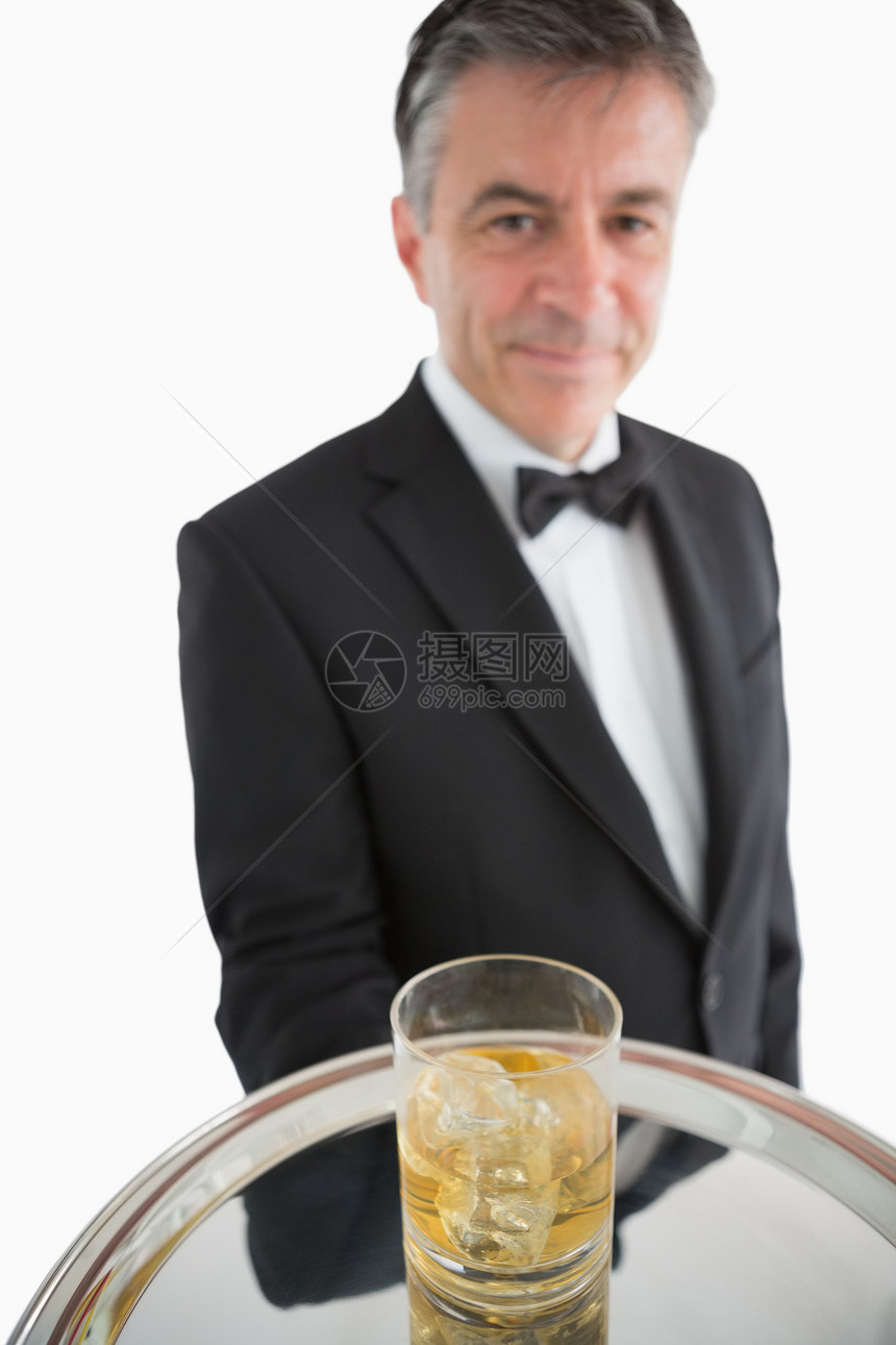 男人用银盘上冰的威士忌服务图片