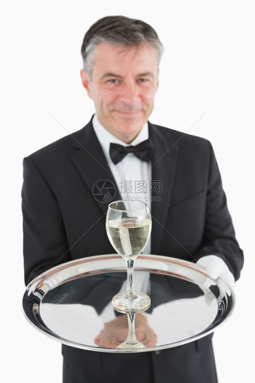 微笑服务员在托盘上供应酒杯图片