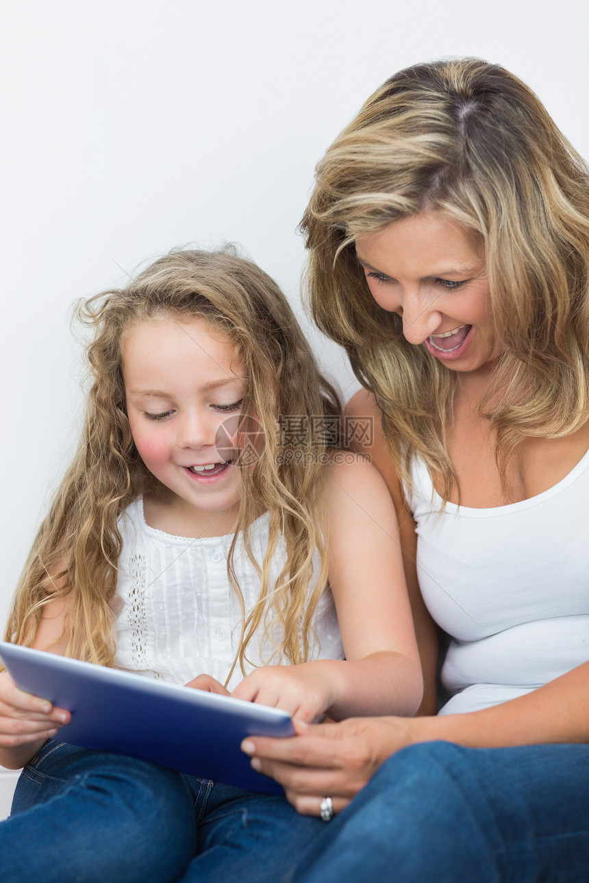 快乐的母亲和女儿看着平板电脑图片