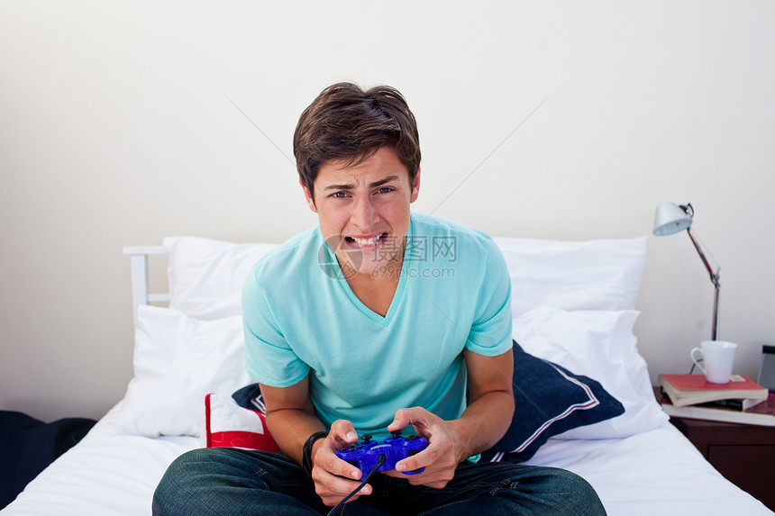 青少年在卧室里玩电子游戏图片