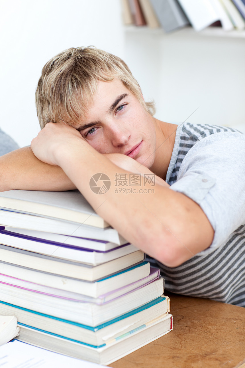 睡在书本上的疲累的食宿者图书馆男生测试工作成功桌子学习青年女性微笑图片