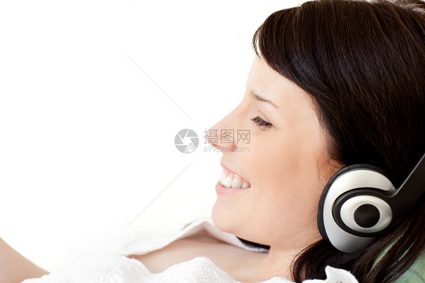 快乐的年轻女子用耳机听音乐微笑手机青年女士幸福成人电话技术女性长椅图片