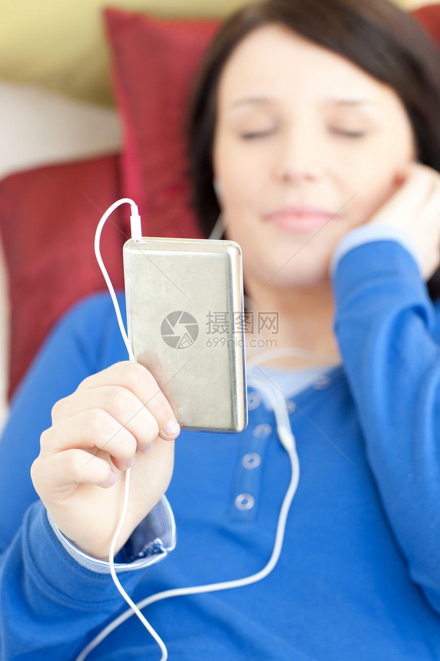 在沙发上听音乐的白人年轻女性女子音乐乐趣幸福女士房间成人客厅快乐耳机音乐播放器图片