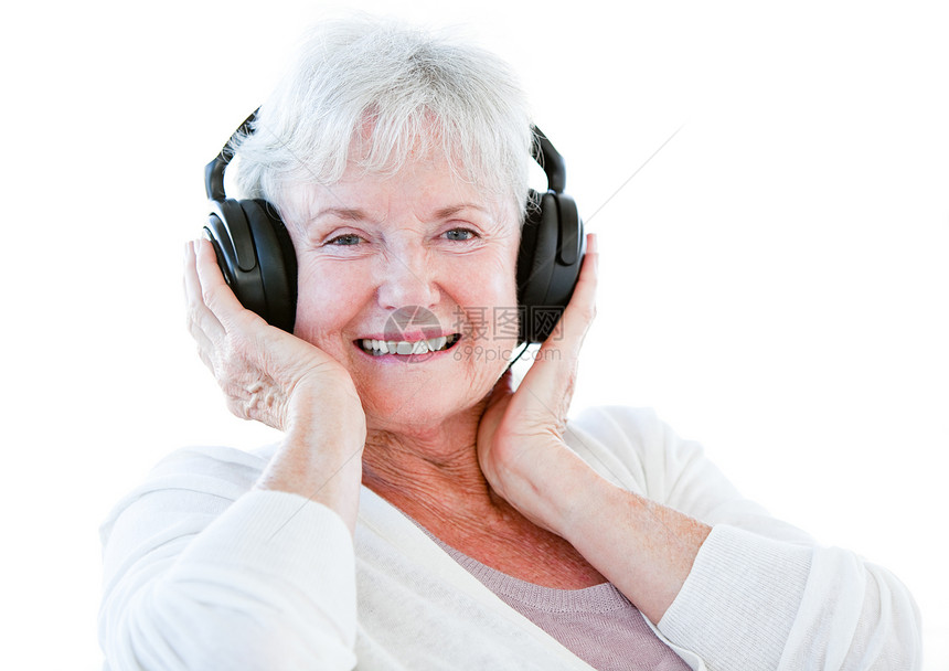 微笑的年长妇女用耳机听音乐图片