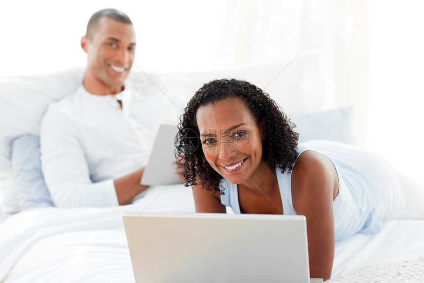 快乐的情侣在床上放松女朋友笔记本男朋友女孩互联网女士卧室电脑家庭成人图片