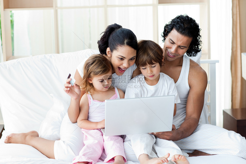 在沙发上用笔记本电脑的家庭互联网妻子女孩技术女性夫妻卧室微笑母亲阅读图片
