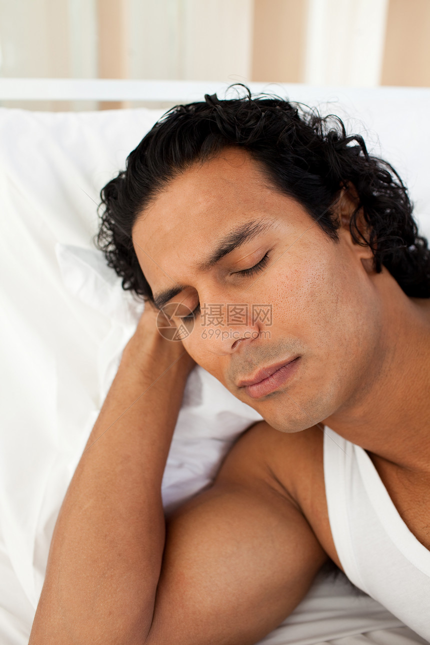迷人的男人睡在床上睡觉图片