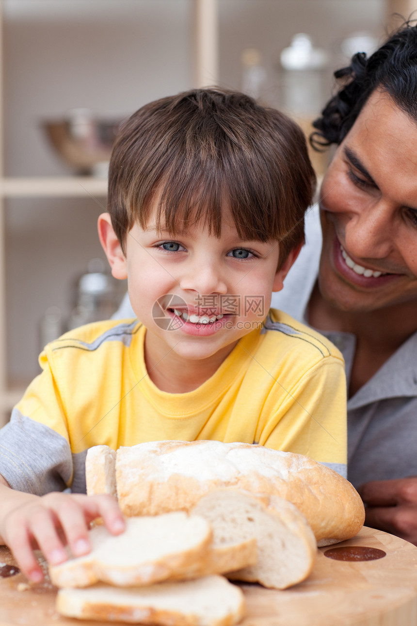 微笑的孩子和他父亲一起吃面包图片