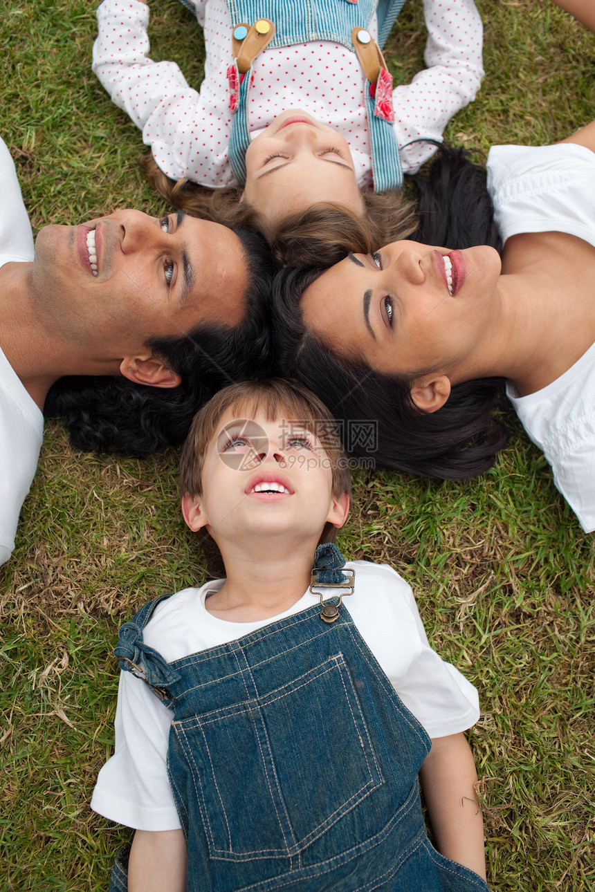 活生生的一家人躺在草地上的圆圈里图片