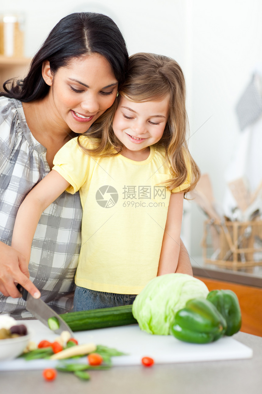 可爱的小女孩和妈妈一起切菜图片