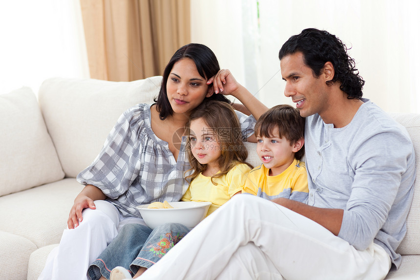 家庭快乐在沙发上看电视享受妈妈孩子们屏幕父亲渠道男性女士女孩孩子图片