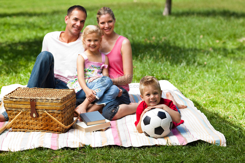 父母和孩子在野餐时放松乐趣太阳天空父亲享受女孩女儿蓝色足球儿子图片
