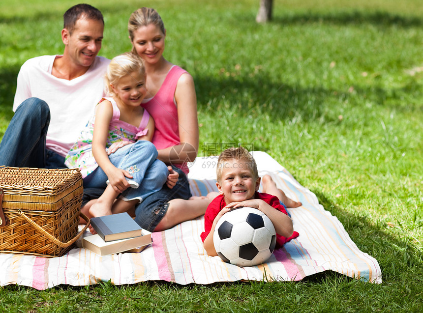 快乐的父母和孩子们在公园野餐图片