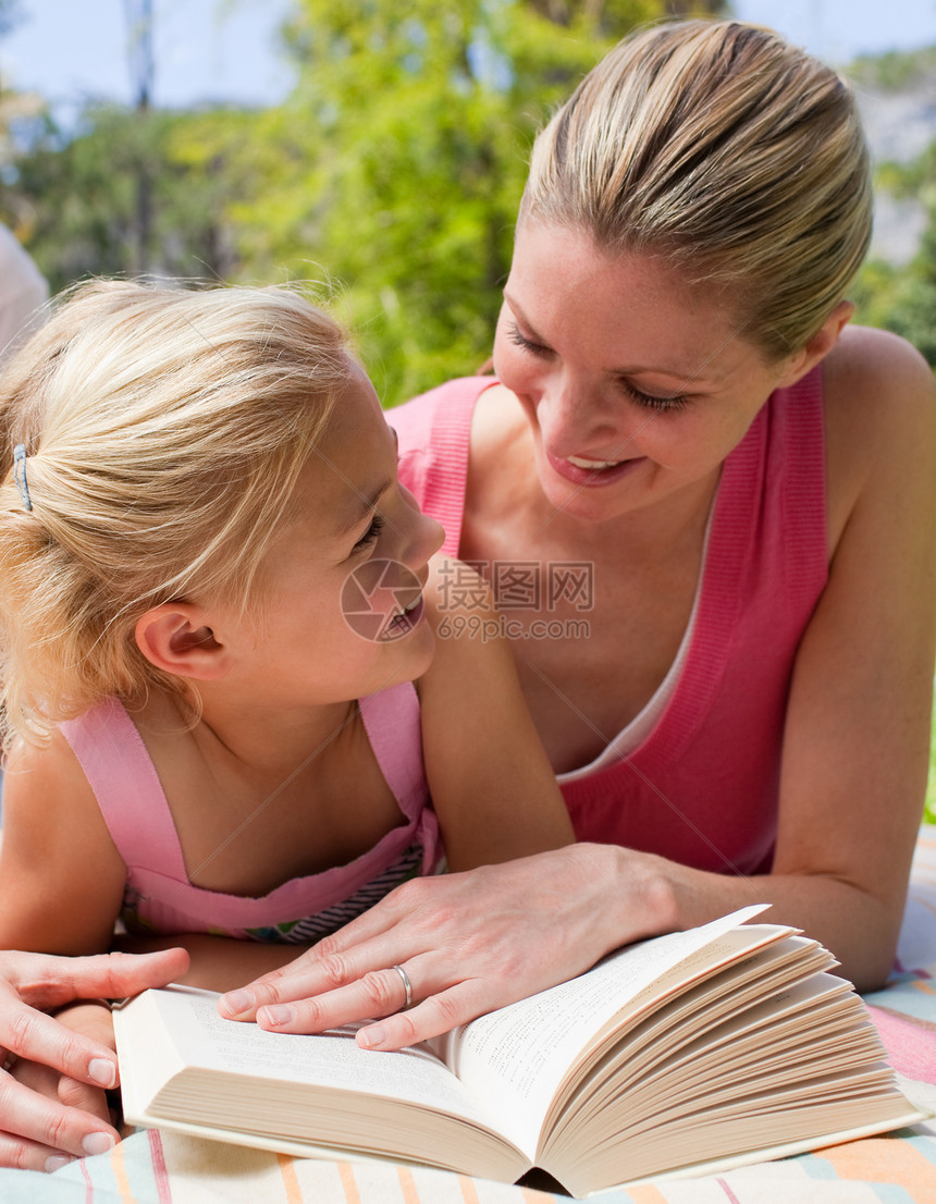 一个微笑的母亲和女儿的肖像 在比斯尼读书图片