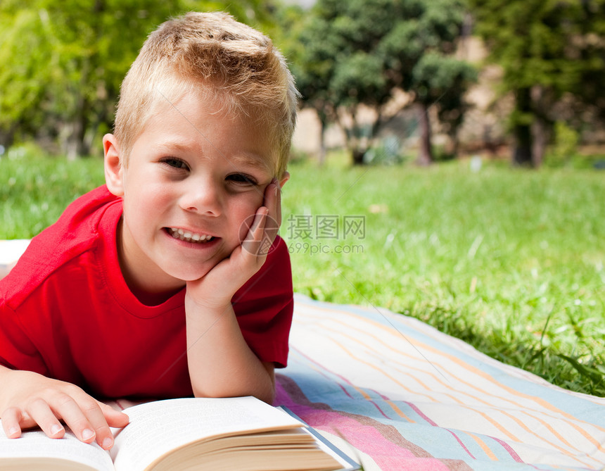 可爱的小男孩在野餐上看书图片