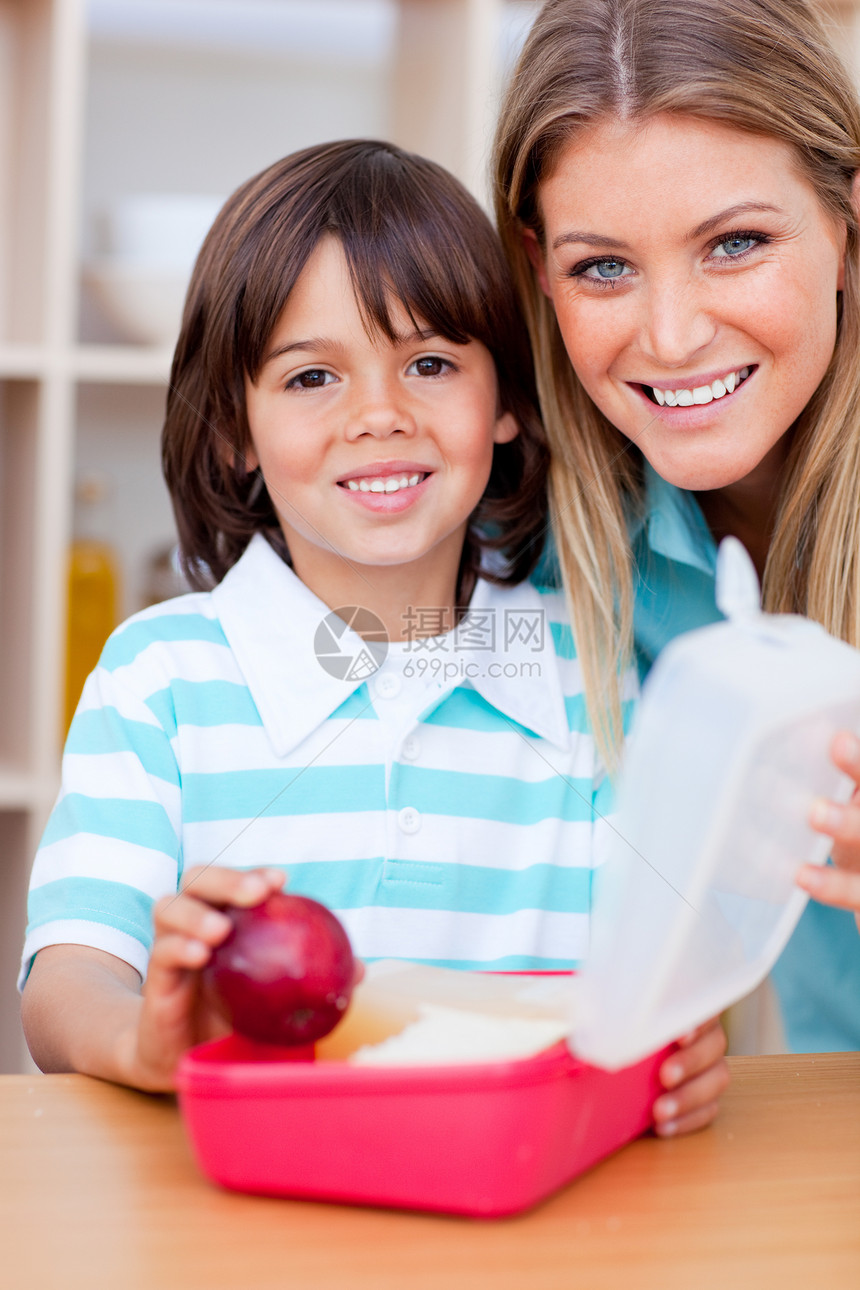 快乐的小男孩和他母亲准备他的零食橙汁水果兄弟营养后代牛奶早餐家庭童年儿子图片