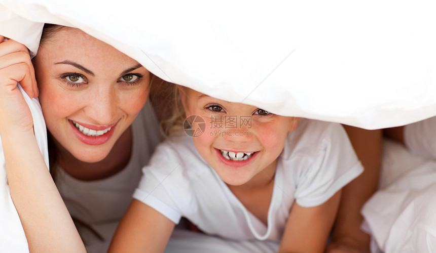 快乐的母亲和她的金发金发女孩一起在床上玩乐趣女士享受微笑卧室生活家庭妈妈女儿拥抱图片