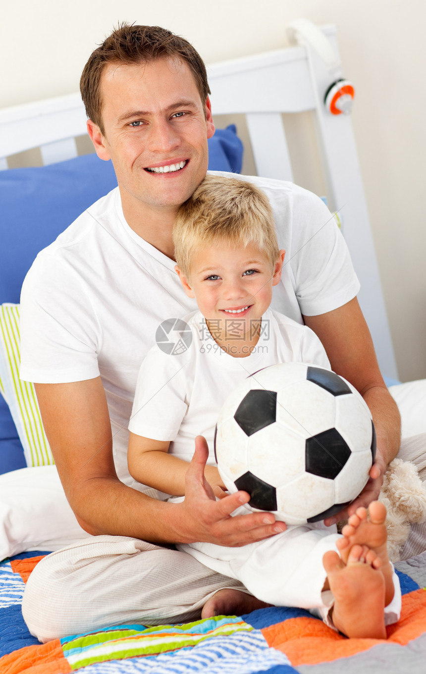 有个小男孩和他父亲在踢足球的酒吧里玩耍图片