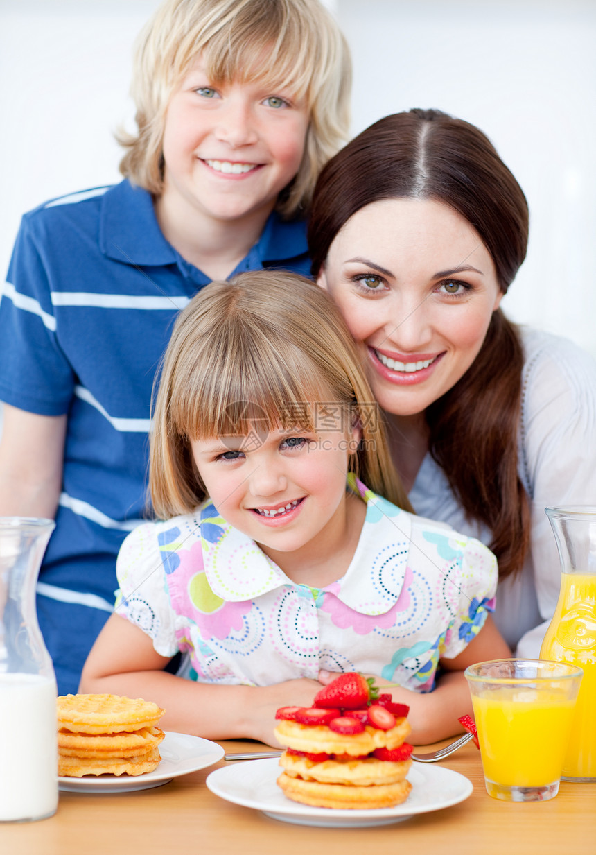 欢乐的母亲和她的孩子 吃草莓的华夫饼图片