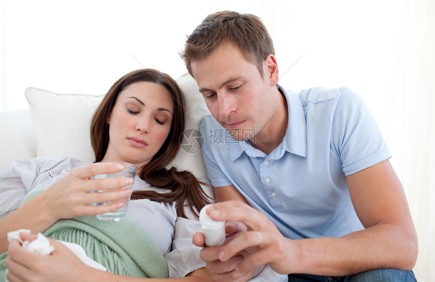 年轻男人带着感冒照顾妻子的年青男人图片