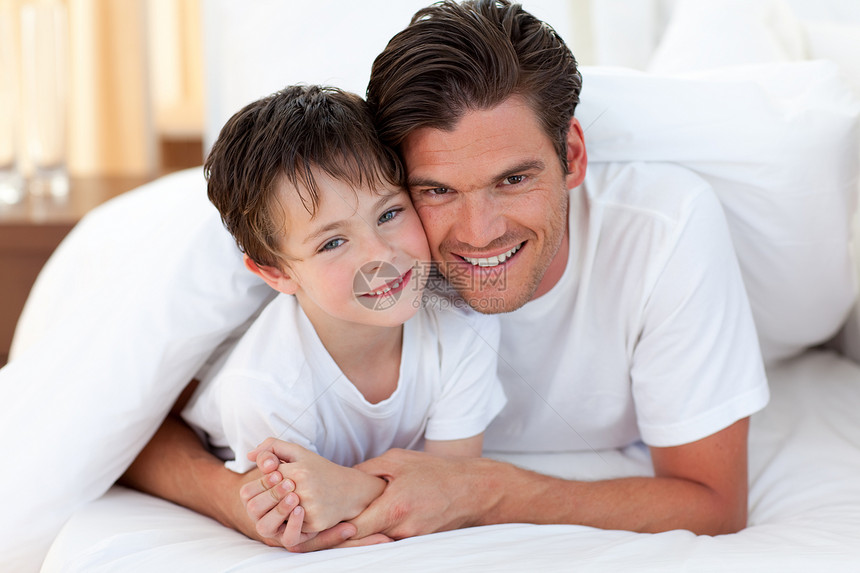 父亲和儿子在床上微笑拥抱生活女士睡衣孩子们男人男生感情父母孩子图片