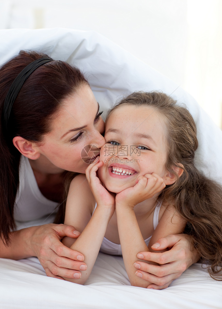 母亲亲吻女儿拥抱享受卧室妈妈感情睡衣孩子父母孩子们喜悦图片